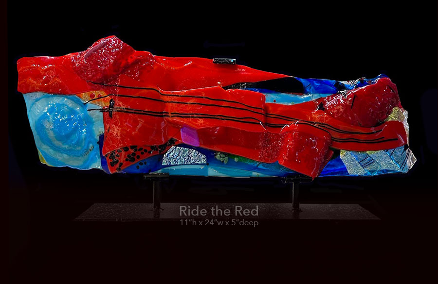 Glass sculpture, on a cutom steel base titled "Ride the Red" 11" h x 24" w x 5" deep. 